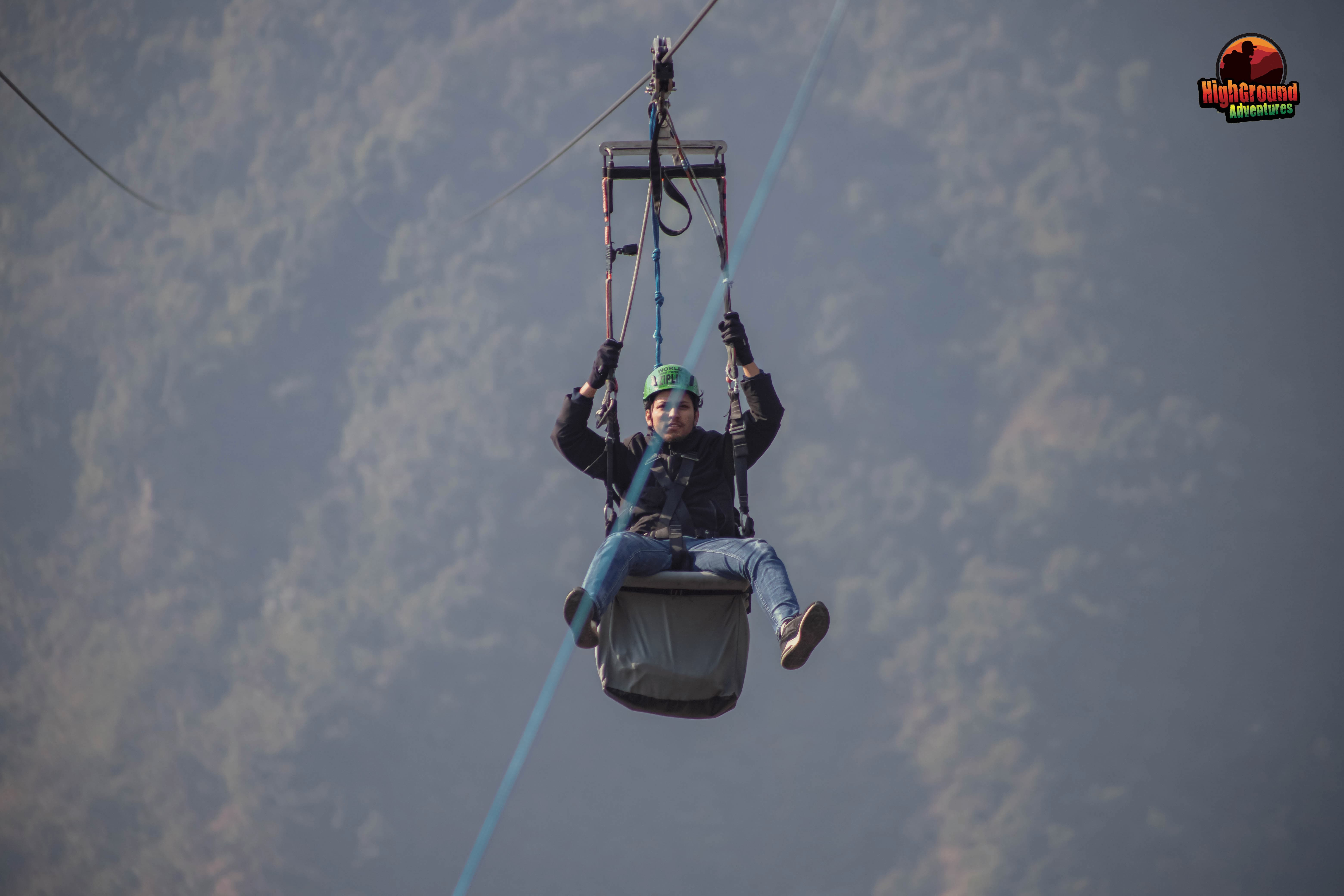 Guest from North Nepal zip flying with backdrop of Sarangkot Hills.